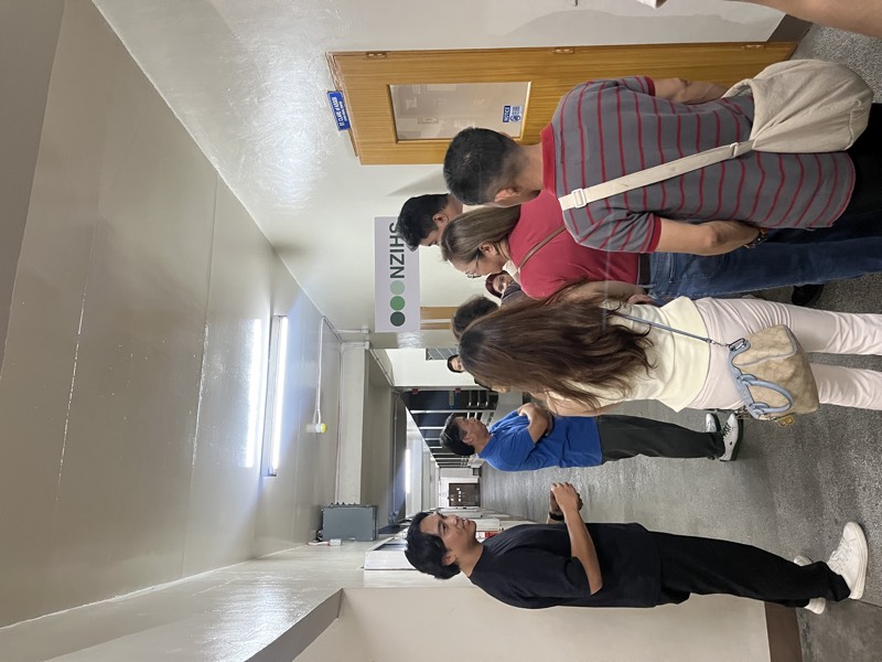 Attendees talk with the team beside an NZIHS sign in the venue corridor at the April 2026 Philippines seminar.